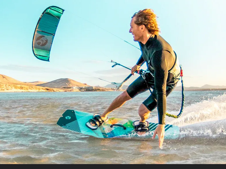 Kitesurf gear lined up at a windy bay station
