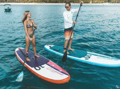Paddle board rental team preparing equipment by the coast
