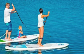 Customer carrying a rental paddle board near the shore